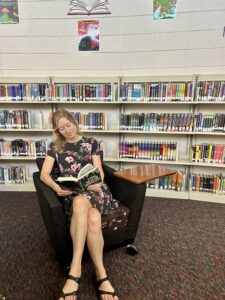 Kristin Schneider as the winner of the 2023-24 Book Trust Teacher of the Year Award, reads a book