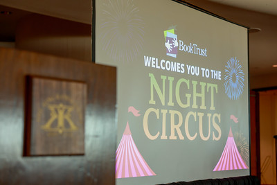 A sign for Book Trust's Night Circus event appears on a screen